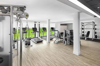 A gym with a variety of equipment including treadmills, weights, and exercise machines.